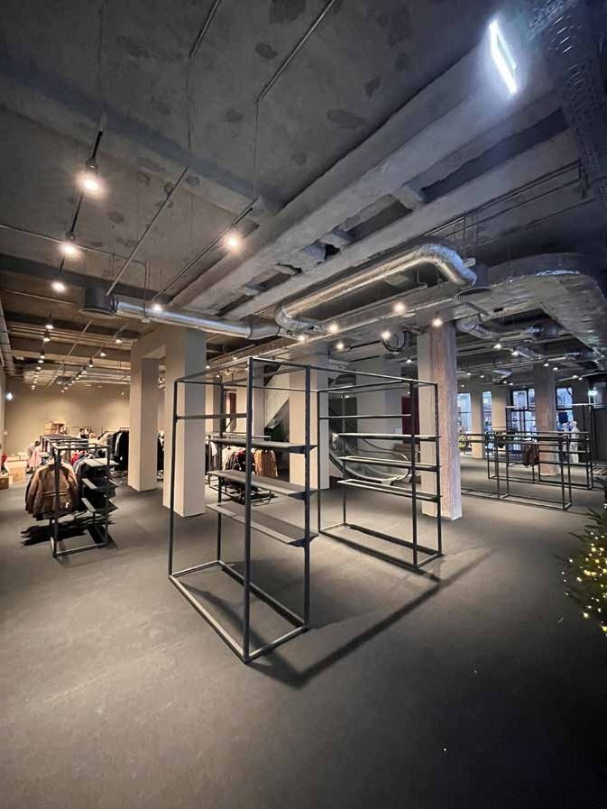 The site at night: black steel shelving in the almost finished sales floor