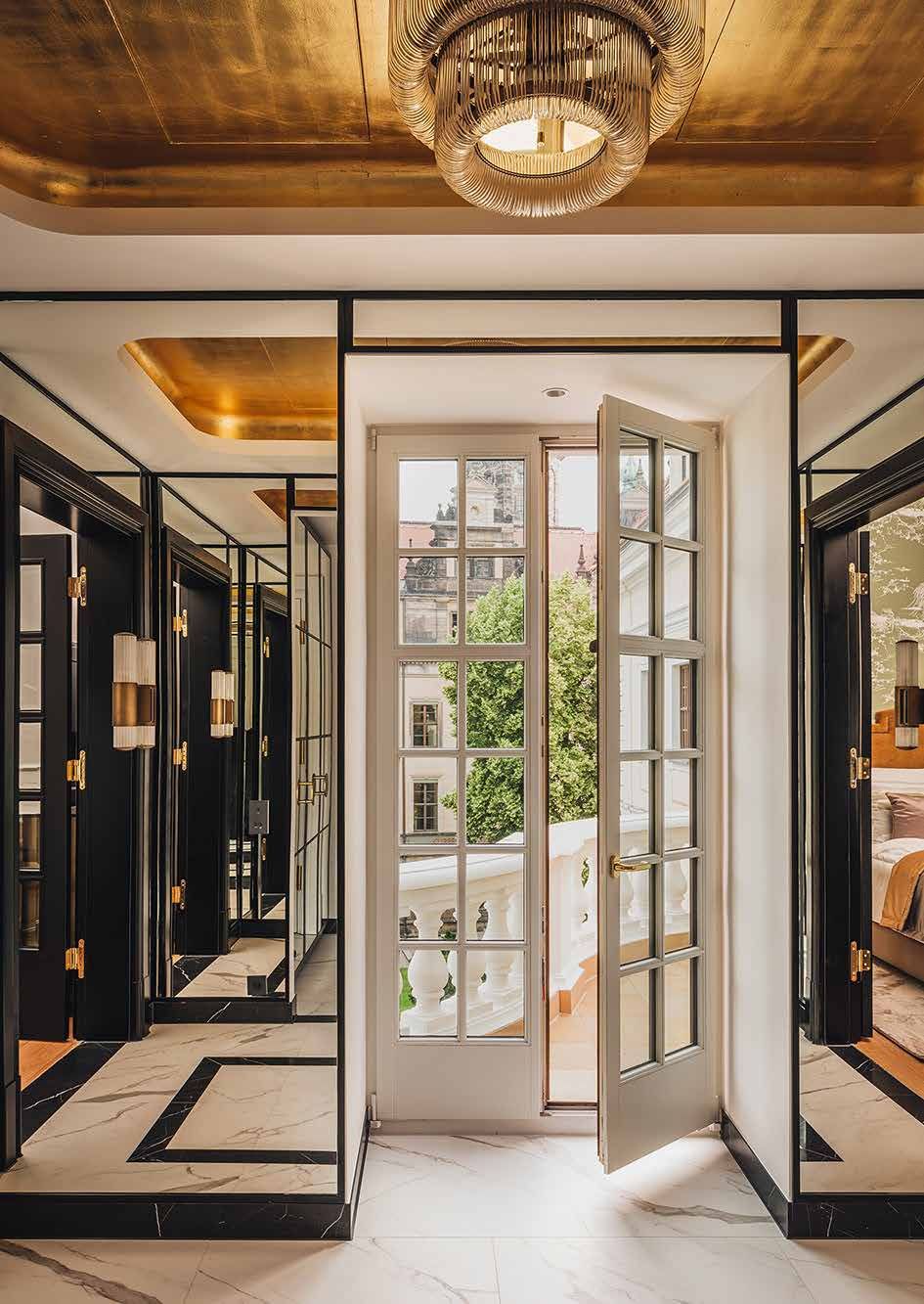 Suite del Taschenbergpalais: portafinestra aperta sul balcone, pareti a specchio con lampade in ottone, soffitto dorato